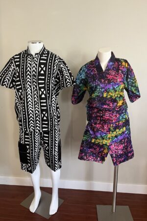 Two mannequins displaying matching African print sets for couples, one in a black and white geometric pattern and the other in a vibrant colorful batik print.