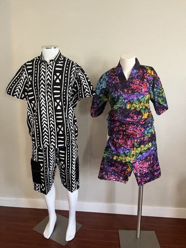 Two mannequins displaying matching African print sets for couples, one in a black and white geometric pattern and the other in a vibrant colorful batik print.